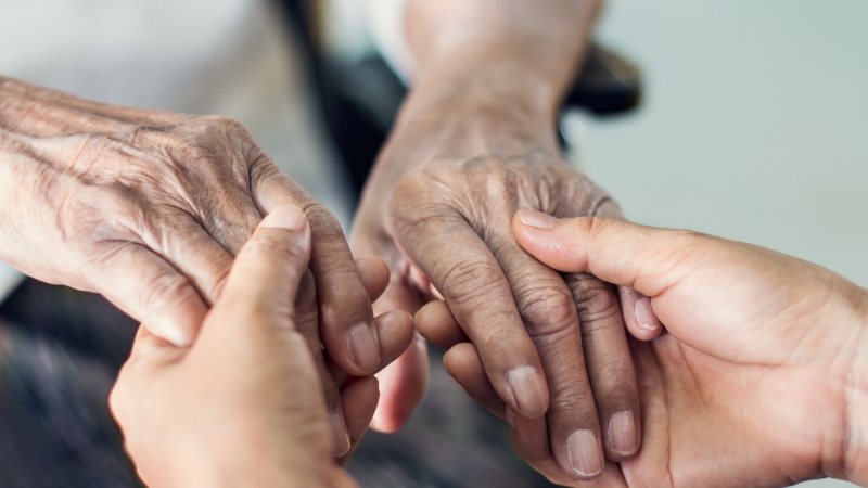 Close up hands of helping hands elderly home care. Mother and daughter. Mental health and elderly care concept Close up hands of helping hands elderly home care. Mother and daughter. Mental health and elderly care concept