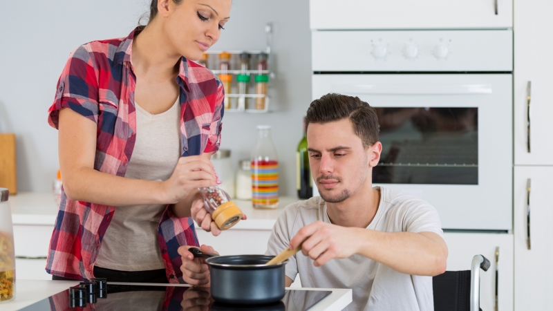 couple cooking together – man disabled on wheelchair couple cooking together – man disabled on wheelchair